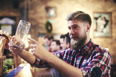Handsome man ordering one beer in the pub の写真素材