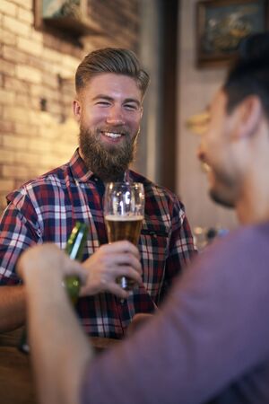 Portrait of smiling man drinking beer in the pub の写真素材