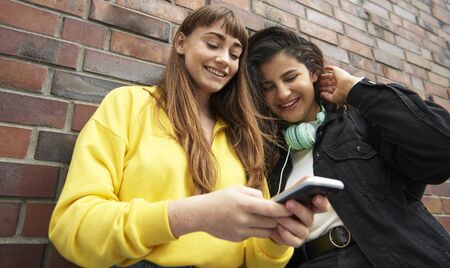 Low angle view of girls with mobile phone 