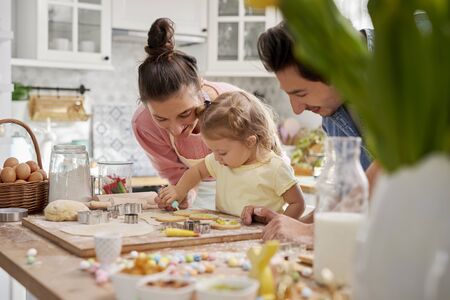 Parents with child decorating cookies for Easterの写真素材