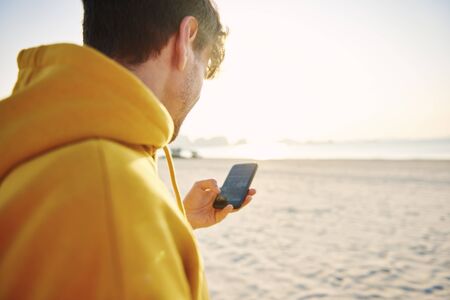 Modern man using mobile phone while joggingの写真素材
