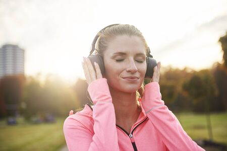 Female athlete with headphones listening to music outdoors