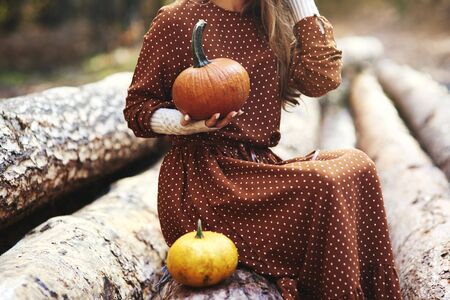 Close up of woman with pumpkin in autumn forest の写真素材
