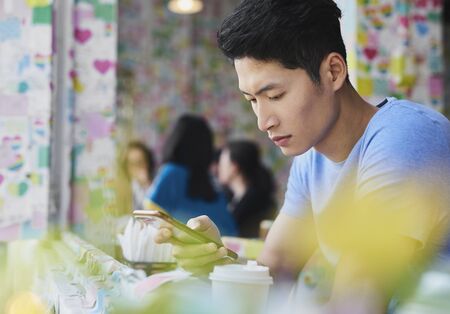 Close up of Vietnamese man with mobile phone at cafe