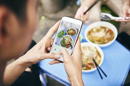 Close up of man photographing his Vietnamese foodの写真素材