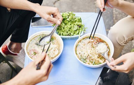 Close up of couple tasting oriental Vietnamese foodの写真素材
