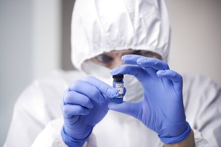 Technician holding an ampule with coronavirus cure