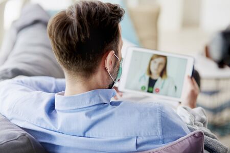 Man having video conference with a doctorの写真素材