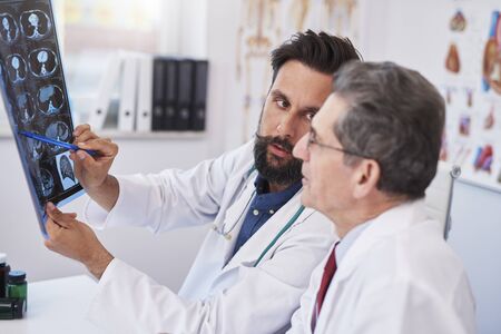 Two busy doctors discussing x-ray image