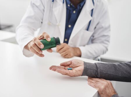 The doctor gives medicine to the patient.の写真素材