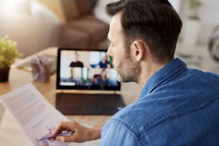 Man analyzing document and having a video conference