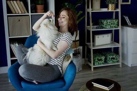 Woman playing with her fluffy dogの写真素材