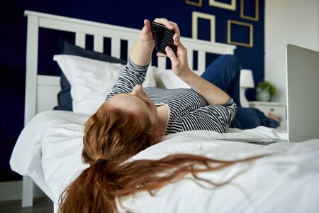 Woman spending time on browsing her phoneの写真素材