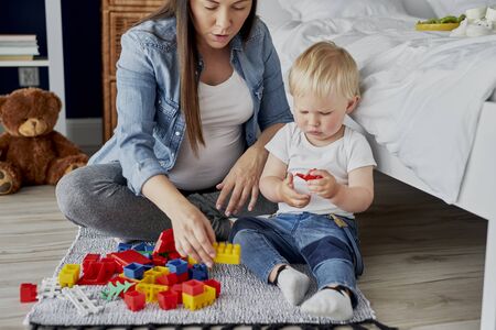 Pregnant mother playing with her baby son