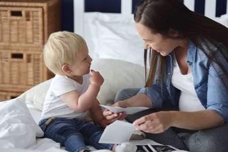 Curious toddler watching pictures of his future brother or sister