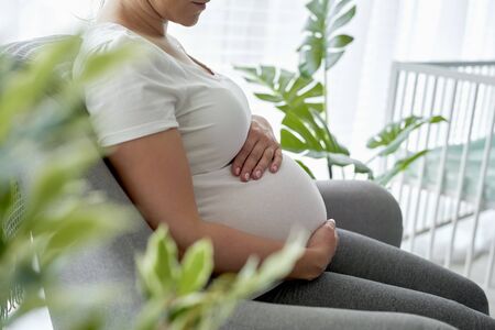 Pregnant woman sitting comfortably in the armchair