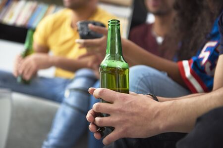 Close up of group of friends with a beer bottle の写真素材