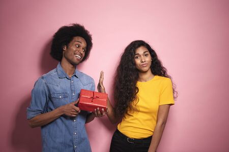 Man giving a gift to a woman in studio shot.の写真素材