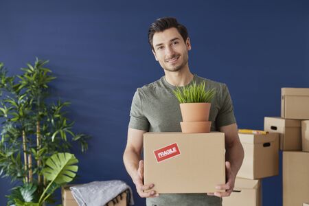 Portrait of young man with a cardboard boxの写真素材