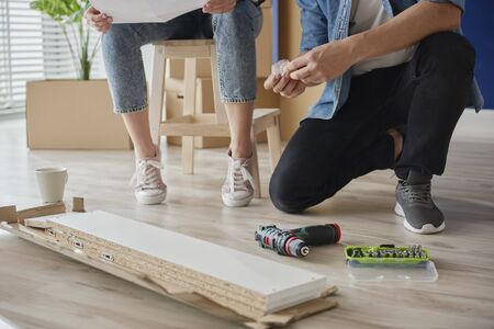 Couple checking manual before installing furnitureの写真素材