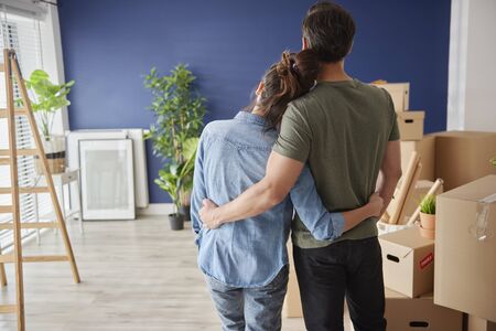 Rear view of couple looking at new house