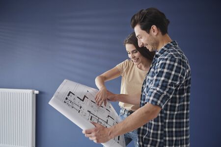 Side view of couple browsing  a home blueprintの写真素材