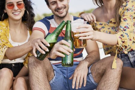 Group of friends doing celebratory toast with beer 