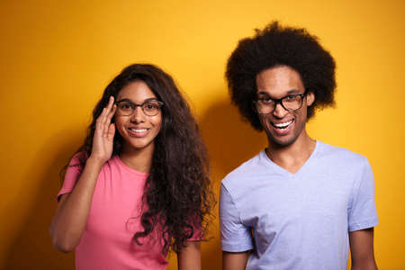 Afroamerican couple in glasses on yellow backgroundの写真素材