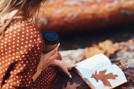 Close up of relaxing with a book and coffee in autumn forestの写真素材