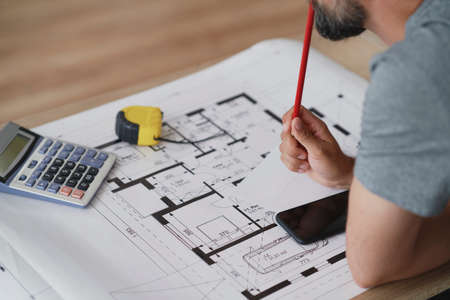 Close up of leaning man thinking about the blueprintsの写真素材