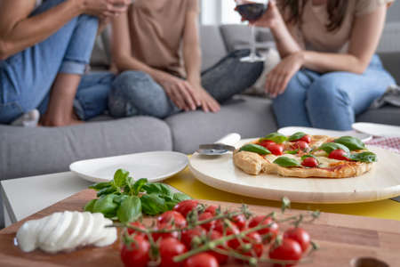 Detail of homemade pizza and wine in the backgroundの写真素材