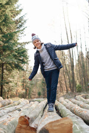 Happy teenage boy having a fun in the autumn forestの写真素材