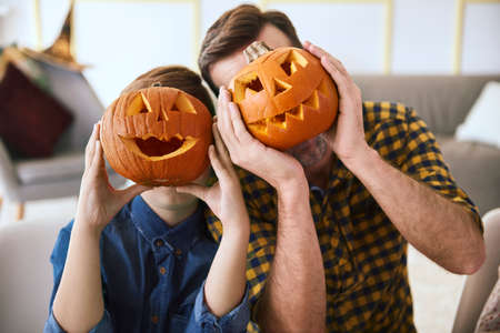 Father and boy with scary Halloween pumpkinの写真素材