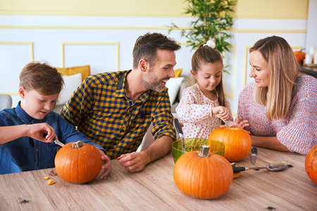 Children carving pumpkins with parentsの写真素材