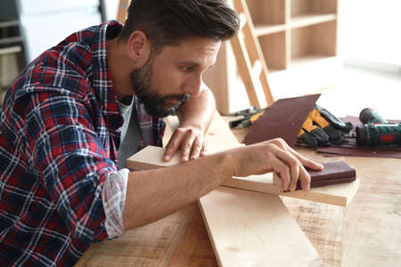 Carpenter at work using sandpaperの写真素材