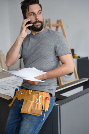 Carpenter consulting the project with the client over the phone