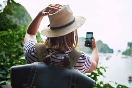 Rear view of woman photographing the natureの写真素材