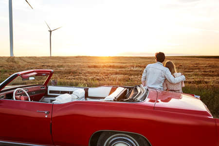 Rear view of couple hugging on a date at sunset