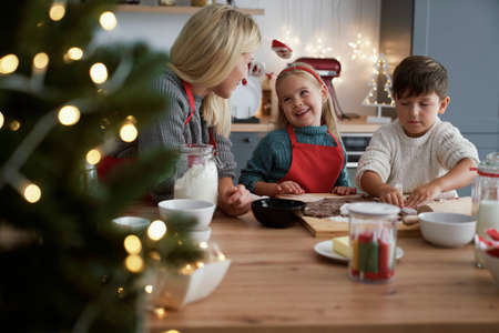 Mother and children crafting Christmas cookiesの写真素材