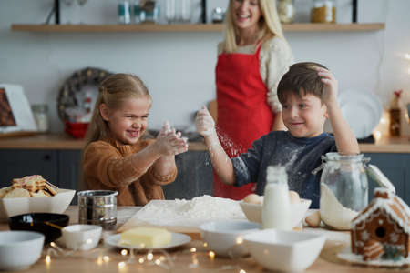 Children having fun while preparing pastry for Christmas cookiesの写真素材