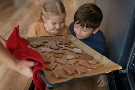Children smelling freshly baked gingerbread cookiesの写真素材
