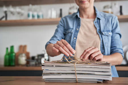 Woman preparing old newspapers for recyclingの写真素材
