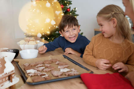 Siblings having fun after baking gingerbread cookies