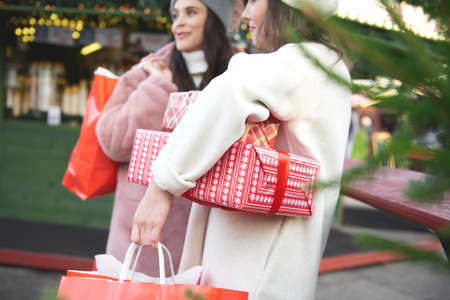 Two women on Christmas Market carrying Christmas presents