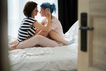 Lesbian couple together in the bedroomの写真素材