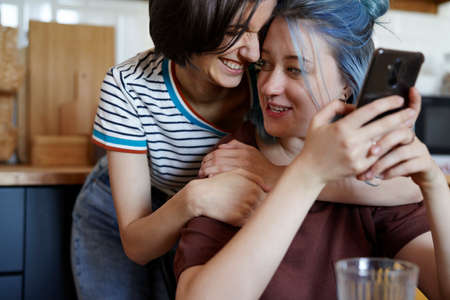 Happy lesbian couple hugging in the kitchen