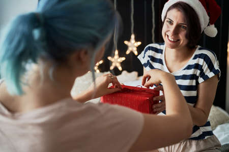 Happy lesbian couple giving Christmas presentsの写真素材