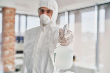 Man holding spray disinfectant in front of the cameraの写真素材