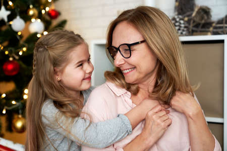 Grandmother and granddaughter looking into each other's eyes during Christmasの写真素材