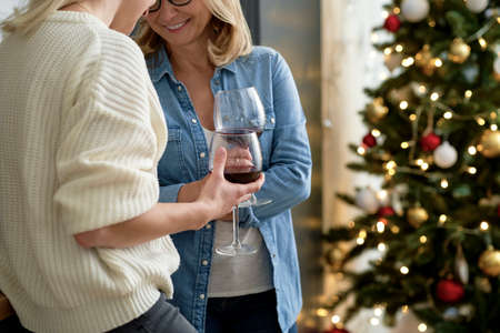 Close up of two women standing with glasses of wineの写真素材
